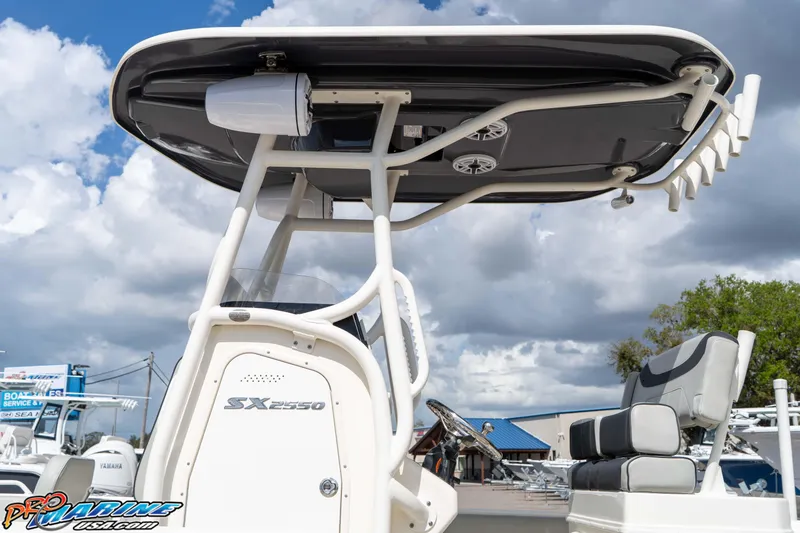 Slide: The Image of 2021 Skeeter SX2550 Family boat with T-top and seating, under a cloudy sky. - 14