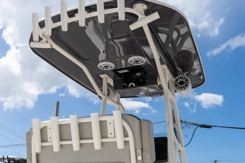 Slide: The Image of 2021 Skeeter SX2550 Family boat with T-top and rod holders against blue sky. - 16