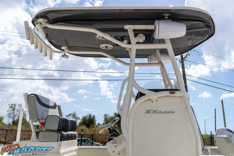 Slide: The Image of 2021 Skeeter SX2550 Family boat with T-top and seating, under a clear sky. - 17