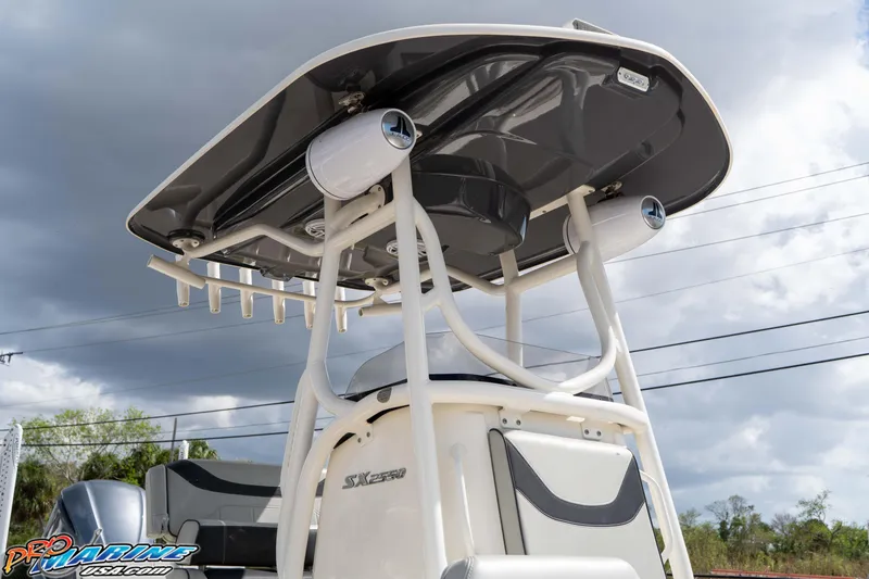 Slide: The Image of 2021 Skeeter SX2550 Family boat with T-top and speakers under cloudy sky. - 18