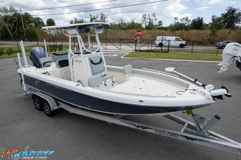 Slide: The Image of 2021 Skeeter SX2550 Family boat on trailer, parked outdoors, showcasing sleek design. - 31