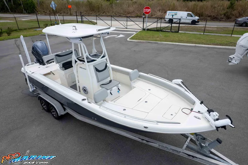 Slide: The Image of 2021 Skeeter SX2550 Family boat on trailer, parked in lot, showcasing sleek design. - 32