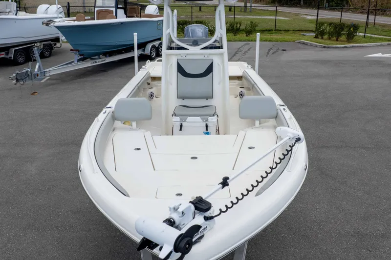 Slide: The Image of 2021 Skeeter SX2550 Family boat, white, parked on pavement, featuring spacious deck and seating. - 34