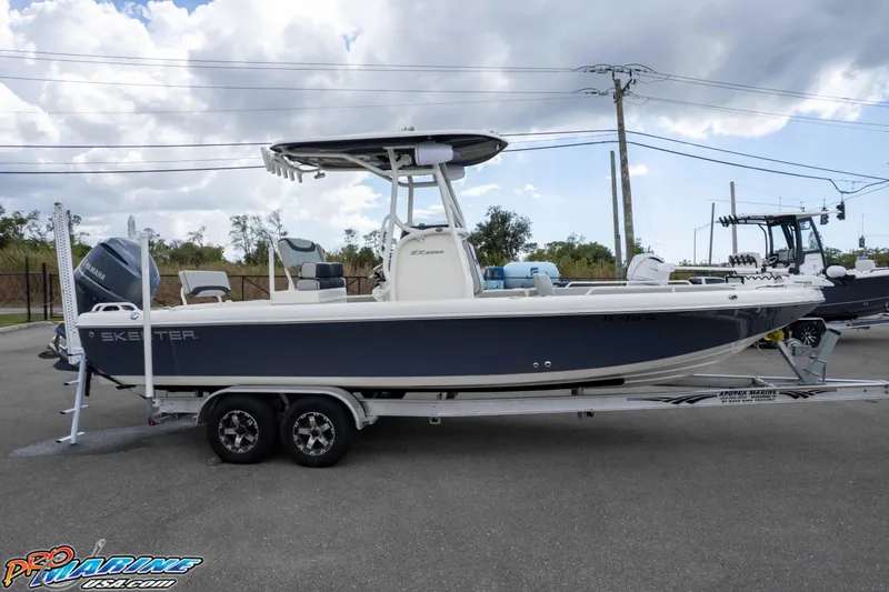 Slide: The Image of 2021 Skeeter SX2550 Family boat on trailer, parked outdoors under cloudy sky. - 51