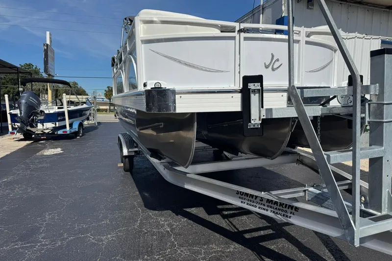 Slide: The Image of 2026 JC Spirit 222 TT Sport pontoon boat on trailer at marina. - 2