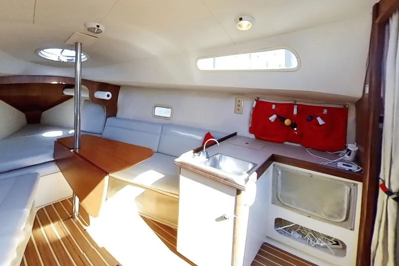 Slide: The Image of Interior of a 2006 Hunter 27 sailboat with seating, table, and kitchenette. - 11