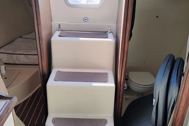 Slide: The Image of Interior of 2006 Hunter 27 sailboat showing stairs, cabin, and toilet area. - 18