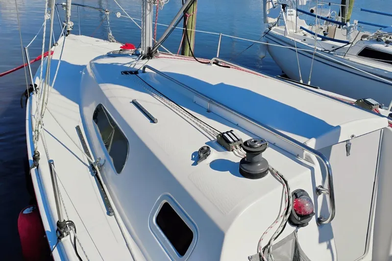 Slide: The Image of 2006 Hunter 27 sailboat deck with winch and rigging, docked on calm water. - 6