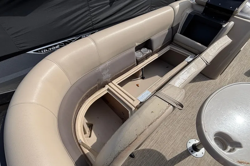 Slide: The Image of 2023 Bentley 243 Navigator boat interior with open storage compartments and beige seating. - 16