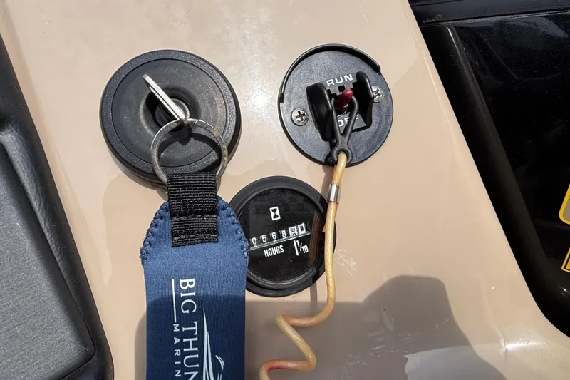 Slide: The Image of Control panel of 2023 Bentley 243 Navigator boat with key and hour meter. - 23