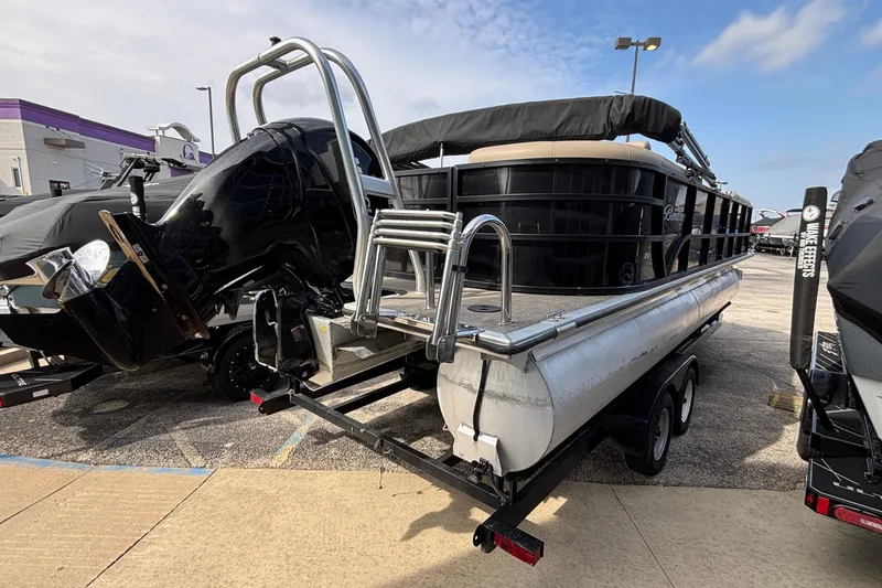 Slide: The Image of 2023 Bentley 243 Navigator pontoon boat with powerful outboard motor, parked on a trailer. - 4