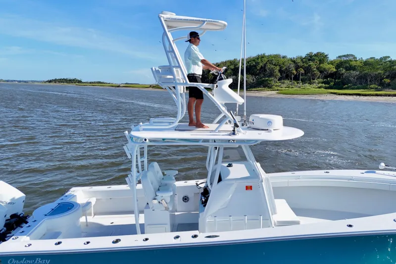 Slide: The Image of 2021 Onslow Bay 33 Tournament boat cruising near a scenic shoreline. - 26