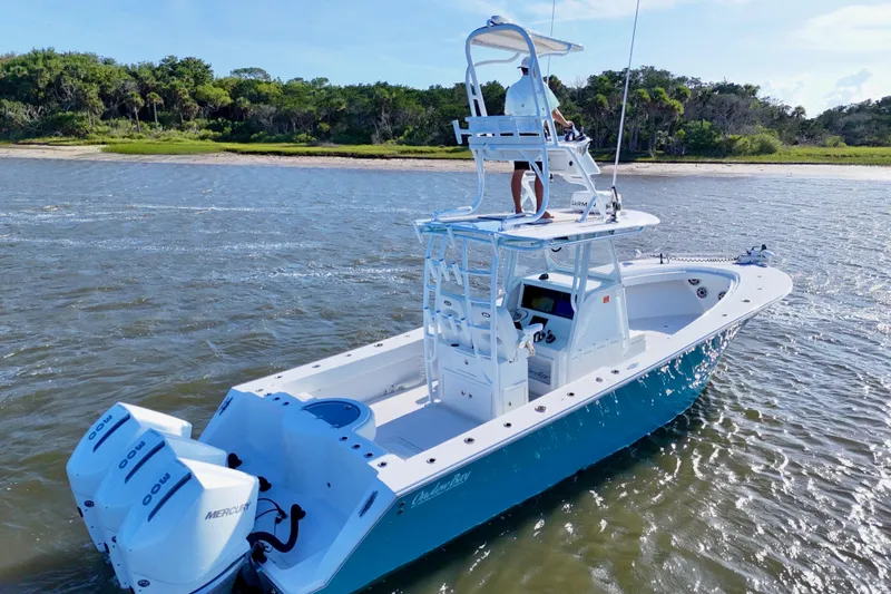 Slide: The Image of 2021 Onslow Bay 33 Tournament boat cruising on a sunny day near a lush shoreline. - 28