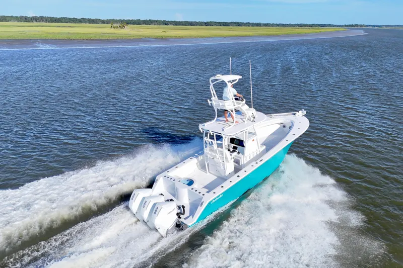 Slide: The Image of 2021 Onslow Bay 33 Tournament boat cruising on open water, showcasing sleek design and powerful engines. - 3