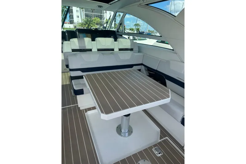 Slide: The Image of 2023 Formula 430 All Sport Crossover interior with seating and table, docked at marina. - 13