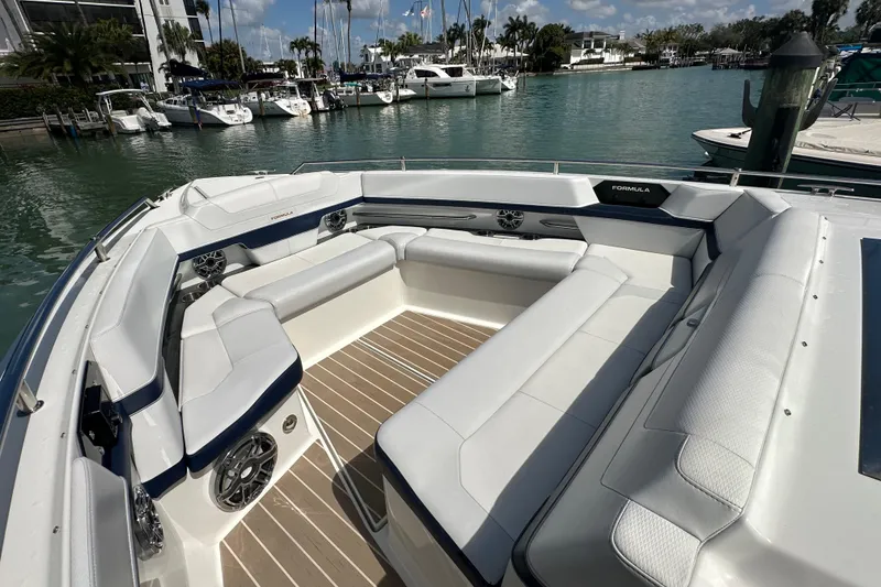 Slide: The Image of 2023 Formula 430 All Sport Crossover boat with spacious seating in a marina setting. - 14