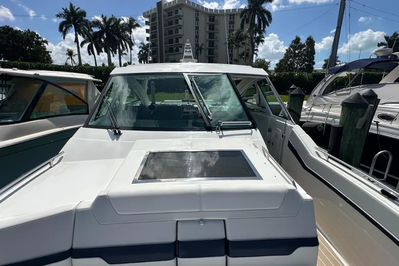Slide: The Image of 2023 Formula 430 All Sport Crossover boat docked, surrounded by palm trees and buildings. - 15
