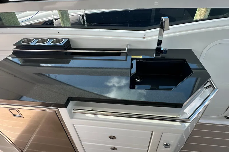Slide: The Image of 2023 Formula 430 All Sport Crossover yacht kitchen with sleek black countertop and modern sink. - 20