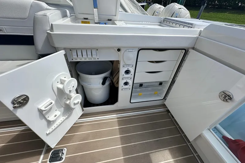 Slide: The Image of 2023 Formula 430 All Sport Crossover boat storage compartments with white bucket and drawers. - 29