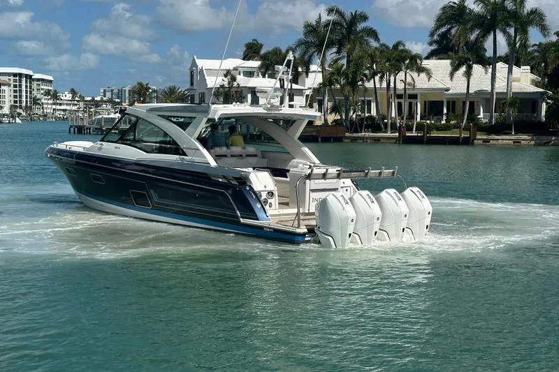 Slide: The Image of 2023 Formula 430 All Sport Crossover boat cruising in a scenic waterfront setting. - 5