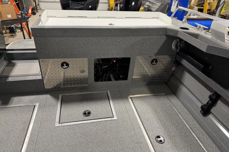 Slide: The Image of 2026 Lund 210 Heavy Gauge boat interior with storage compartments and diamond plate accents. - 10