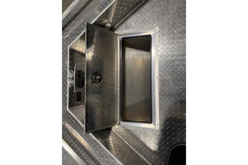 Slide: The Image of Open storage compartment on 2026 Lund 210 Heavy Gauge boat with diamond plate surface. - 14