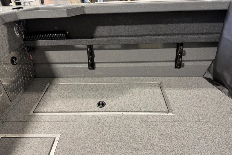 Slide: The Image of 2026 Lund 210 Heavy Gauge boat interior with storage compartments and durable flooring. - 17