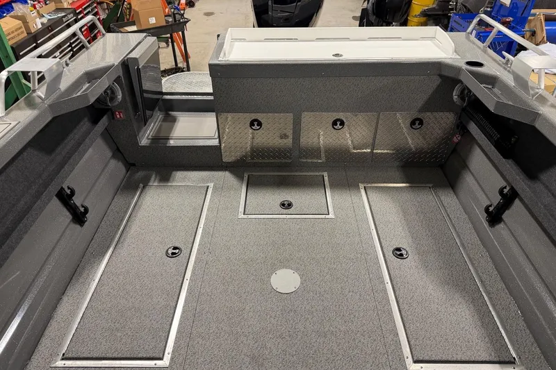 Slide: The Image of 2026 Lund 210 Heavy Gauge boat interior with storage compartments and durable flooring. - 21