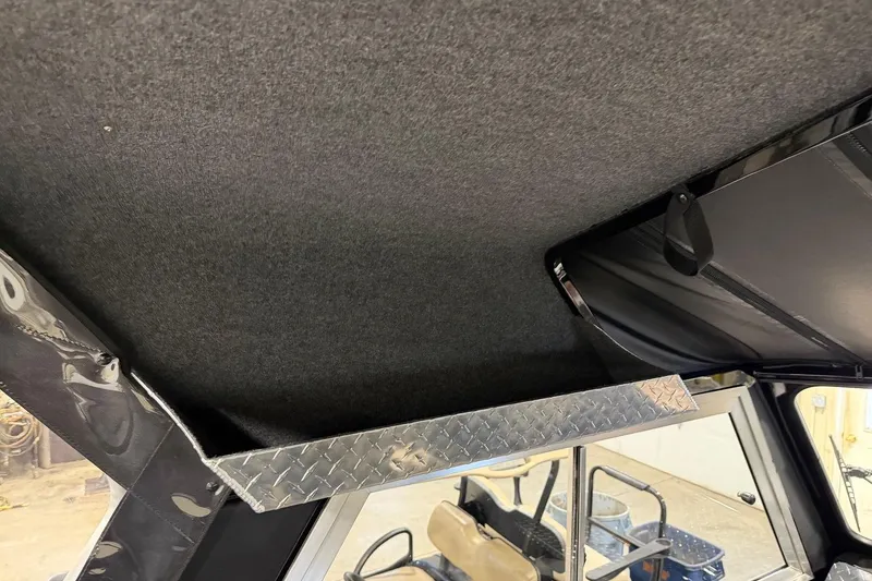 Slide: The Image of Interior view of 2026 Lund 210 Heavy Gauge boat with diamond plate storage shelf. - 26