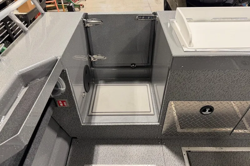 Slide: The Image of 2026 Lund 210 Heavy Gauge boat interior with storage compartments and metallic finish. - 27