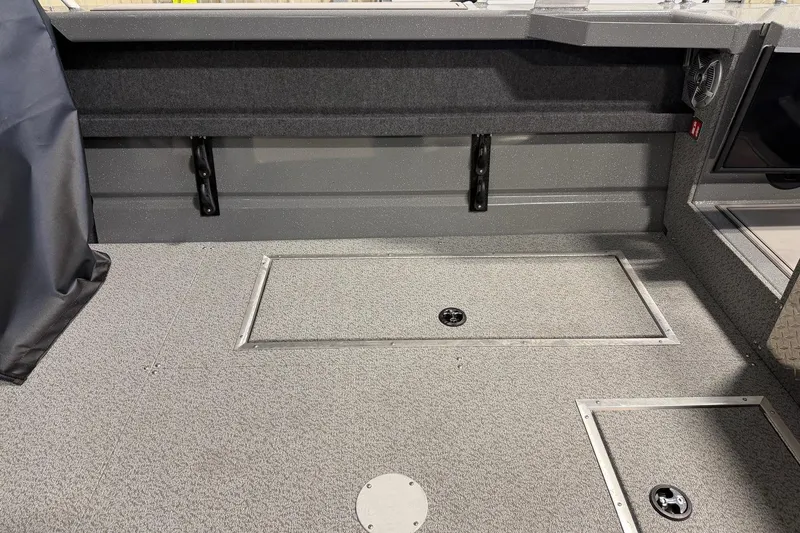 Slide: The Image of 2026 Lund 210 Heavy Gauge boat interior with storage compartments and durable flooring. - 6