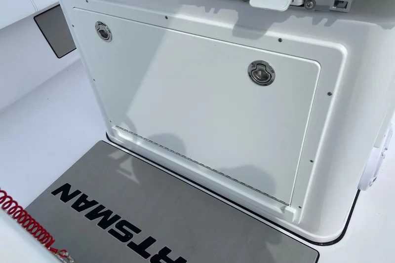Slide: The Image of 2026 Sportsman Masters 267 Bay Boat deck with storage compartment and branded mat. - 11