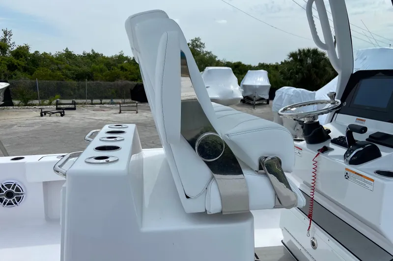 Slide: The Image of 2026 Sportsman Masters 267 Bay Boat helm with white seating and steering wheel. - 16