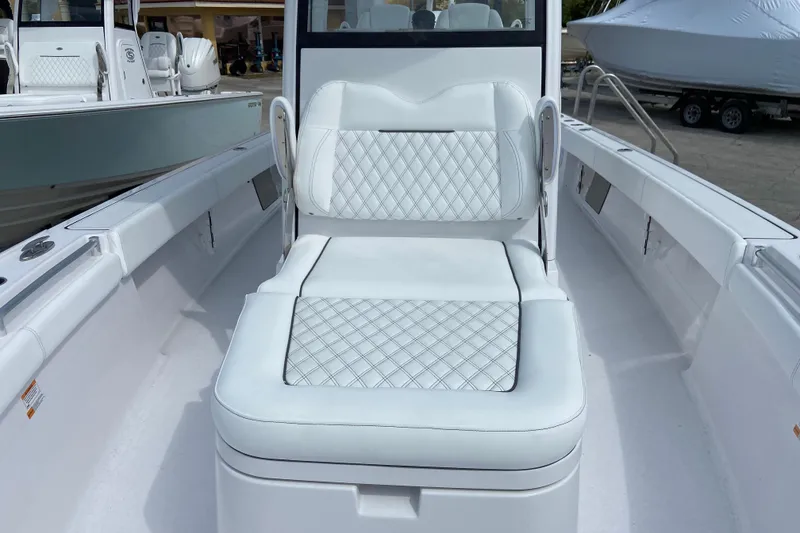 Slide: The Image of 2026 Sportsman Masters 267 Bay Boat with white cushioned seating and sleek design. - 24