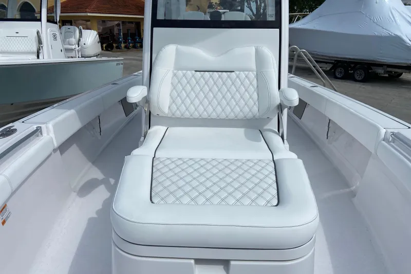 Slide: The Image of 2026 Sportsman Masters 267 Bay Boat with white cushioned seating and diamond stitching. - 25