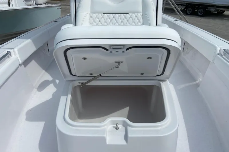 Slide: The Image of Open storage compartment on 2026 Sportsman Masters 267 Bay Boat, featuring white cushioned seating. - 26