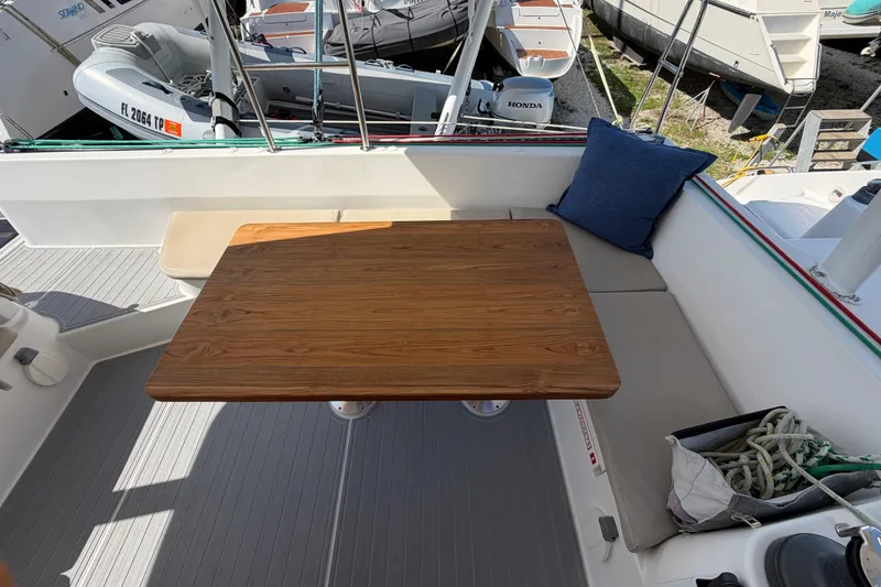 Slide: The Image of Cozy seating area on 2014 Outremer 45 catamaran with wooden table and cushion. - 11