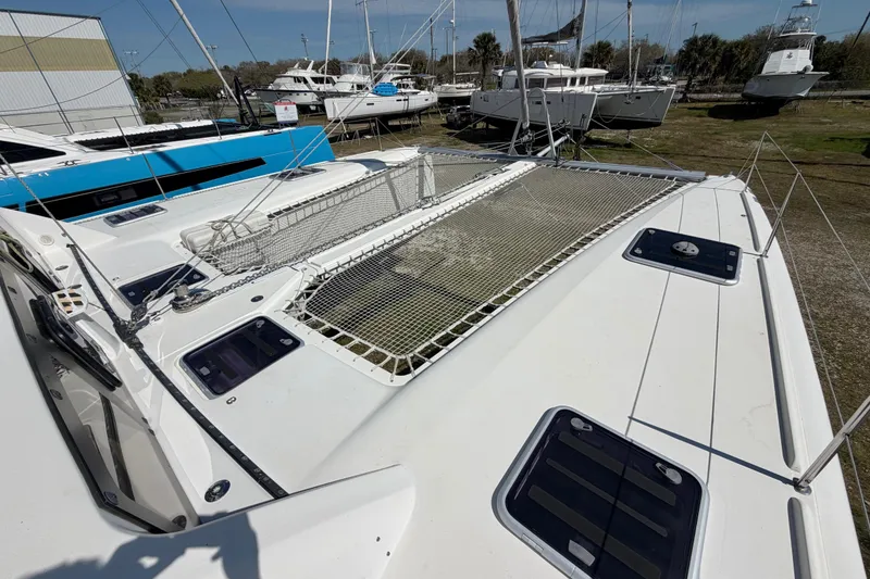 Slide: The Image of 2014 Outremer 45 catamaran on land, showcasing deck and netting. - 17
