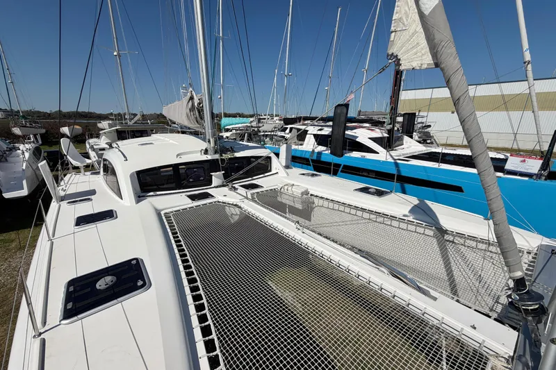 Slide: The Image of 2014 Outremer 45 catamaran with netted deck, docked alongside other boats. - 18