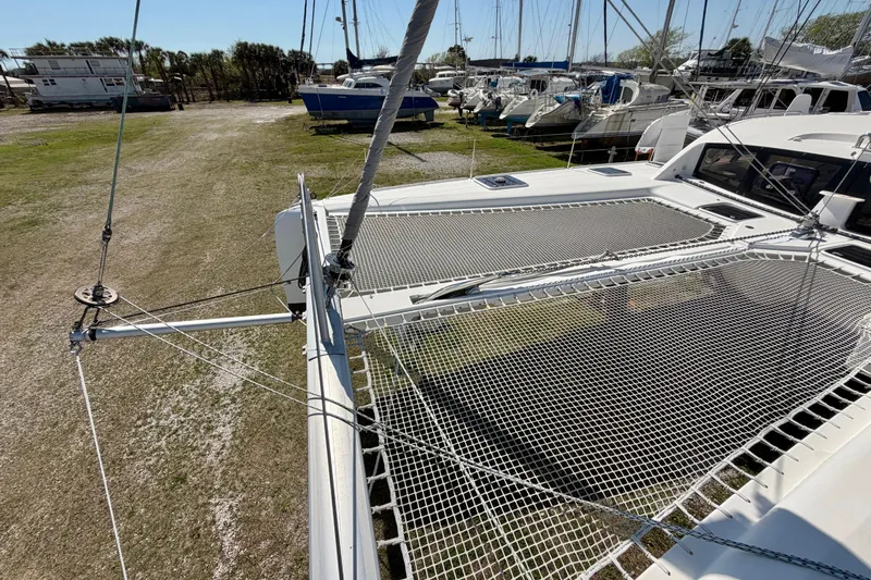 Slide: The Image of 2014 Outremer 45 catamaran with netting on deck, docked in a marina. - 22