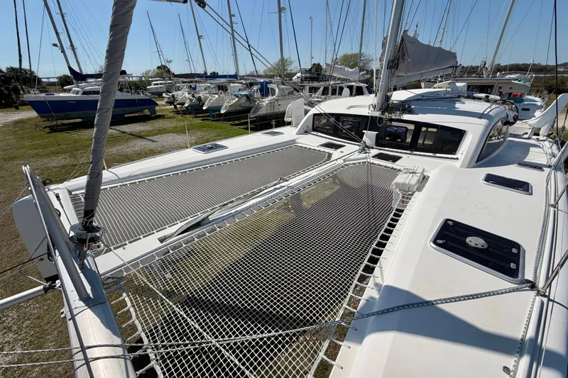 Slide: The Image of 2014 Outremer 45 catamaran on land, showcasing deck and netting. - 23
