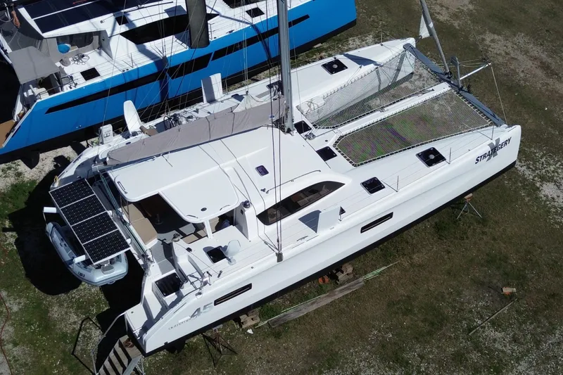Slide: The Image of 2014 Outremer 45 catamaran with solar panels, docked on land. - 4