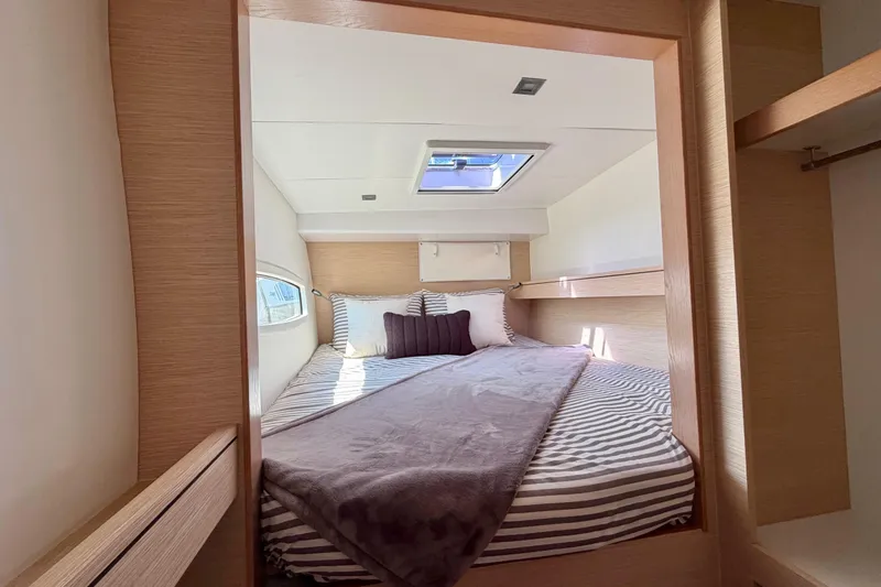 Slide: The Image of Cozy bedroom interior of 2014 Outremer 45 yacht with striped bedding and skylight. - 44