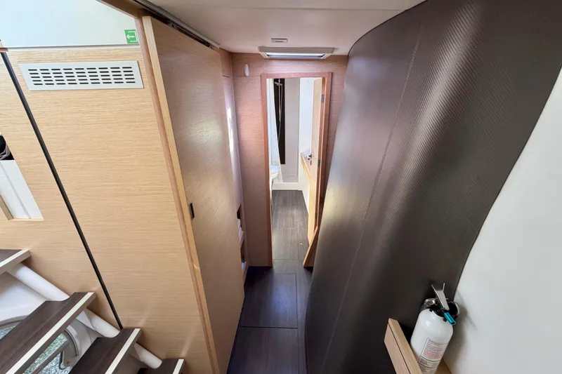 Slide: The Image of Interior hallway of a 2014 Outremer 45 catamaran, featuring modern wood paneling and sleek design. - 46