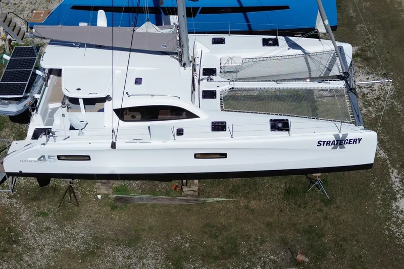 Slide: The Image of 2014 Outremer 45 catamaran on land, featuring solar panels and netted deck. - 5