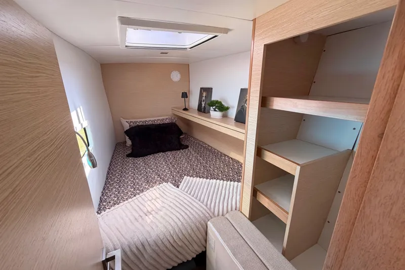 Slide: The Image of Cozy cabin interior of 2014 Outremer 45 yacht with bed, shelves, and skylight. - 61