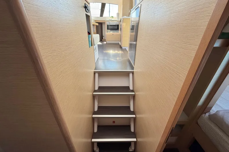 Slide: The Image of Interior view of 2014 Outremer 45 yacht, featuring stairs leading to the kitchen area. - 63