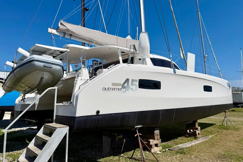 Slide: The Image of 2014 Outremer 45 catamaran on land, featuring sleek design and modern amenities. - 90