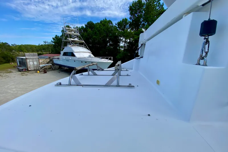 Slide: The Image of 2000 Carver 450 Voyager Pilothouse yacht on land, surrounded by trees and equipment. - 91