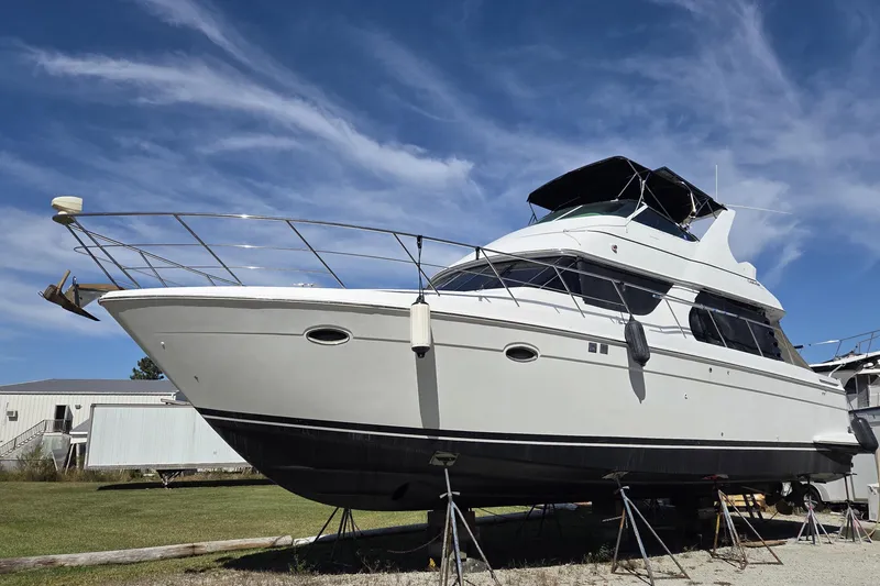 Slide: The Image of 2000 Carver 450 Voyager Pilothouse yacht on stands under a clear blue sky. - 1
